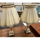 A pair of onyx table lamps of urn shape on square bases and gilt feet