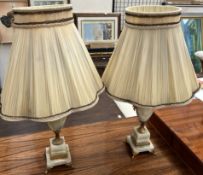 A pair of onyx table lamps of urn shape on square bases and gilt feet
