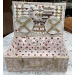 A Wicker hamper with a setting for four including plates,