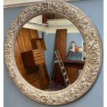 A large circular wall mirror decorated with fruit,