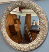 A large circular wall mirror decorated with fruit,