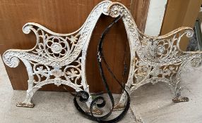 A pair of cast iron bench ends decorated with flowers and leaves together with a pair of scrolling