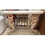 A cast iron and reconstituted stone console table with a rectangular top with cut corners,