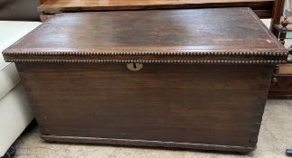 An oak coffer with a rectangular top with carrying handles