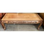 A Chinese hardwood coffee table with a rectangular top and dragon carved border on cabriole legs