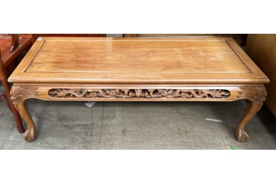 A Chinese hardwood coffee table with a rectangular top and dragon carved border on cabriole legs