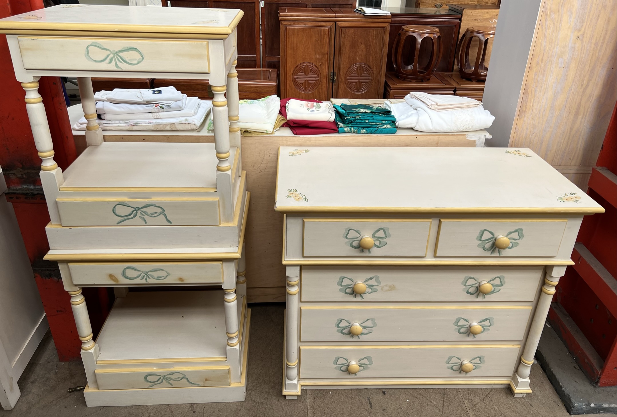 A modern cream and yellow painted chest with two short and three long drawers together with a pair