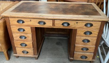 A pedestal desk with two long drawers and an arrangement of eight drawers on square legs