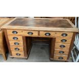 A pedestal desk with two long drawers and an arrangement of eight drawers on square legs