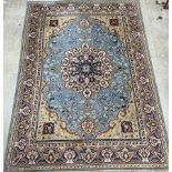 A large Persian rug with a blue ground and central radiating medallion,