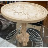 A simulated ivory wine table moulded with figures in a carriage,