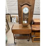 A mahogany tea trolley with two tiers and drop flaps on casters together with a modern wall clock