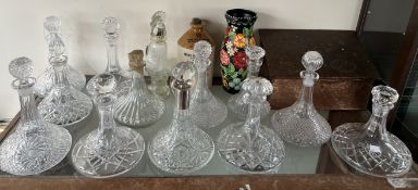 A copper Slippers box together with a collection of crystal glass ships decanters, other decanters,