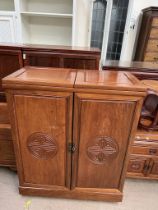 A Chinese hardwood bar, with a foldover top and two hinged doors with a fitted interior,