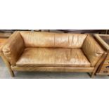 A John Lewis brown leather two seater settee with fixed cushions on square tapering legs