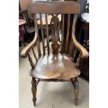A 19th century kitchen elbow chair with a pierced vase splat and a solid seat on turned legs