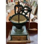 An early 20th century French Peugeot cast iron coffee grinder with a base drawer on a wooden base