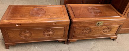 A pair of Chinese hardwood coffer with a hinged rectangular top and carved front on bracket feet,