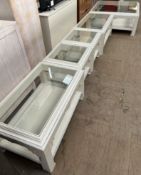 A set of five cream and blue painted glass topped coffee tables of varying sizes