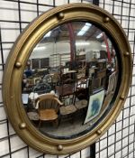 A gilt decorated convex wall mirror with ball mounts