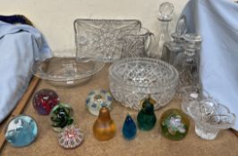 A collection of glass paperweights together with glass decanters,