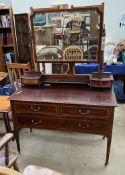 An Edwardian mahogany dressing table, with a shaped bevelled mirror,