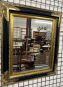 A gilt and ebonised wall mirror of rectangular form with a bevelled plate