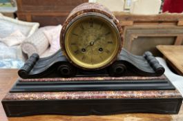 A black slate and marble mantle clock, with a circular form,