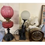 A Victorian oil lamp with a cranberry glass reservoir together with an Art Deco style lamp,