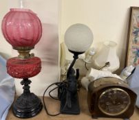 A Victorian oil lamp with a cranberry glass reservoir together with an Art Deco style lamp,