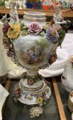 A continental porcelain vase with twin figural handles, flowerheads and leaves,