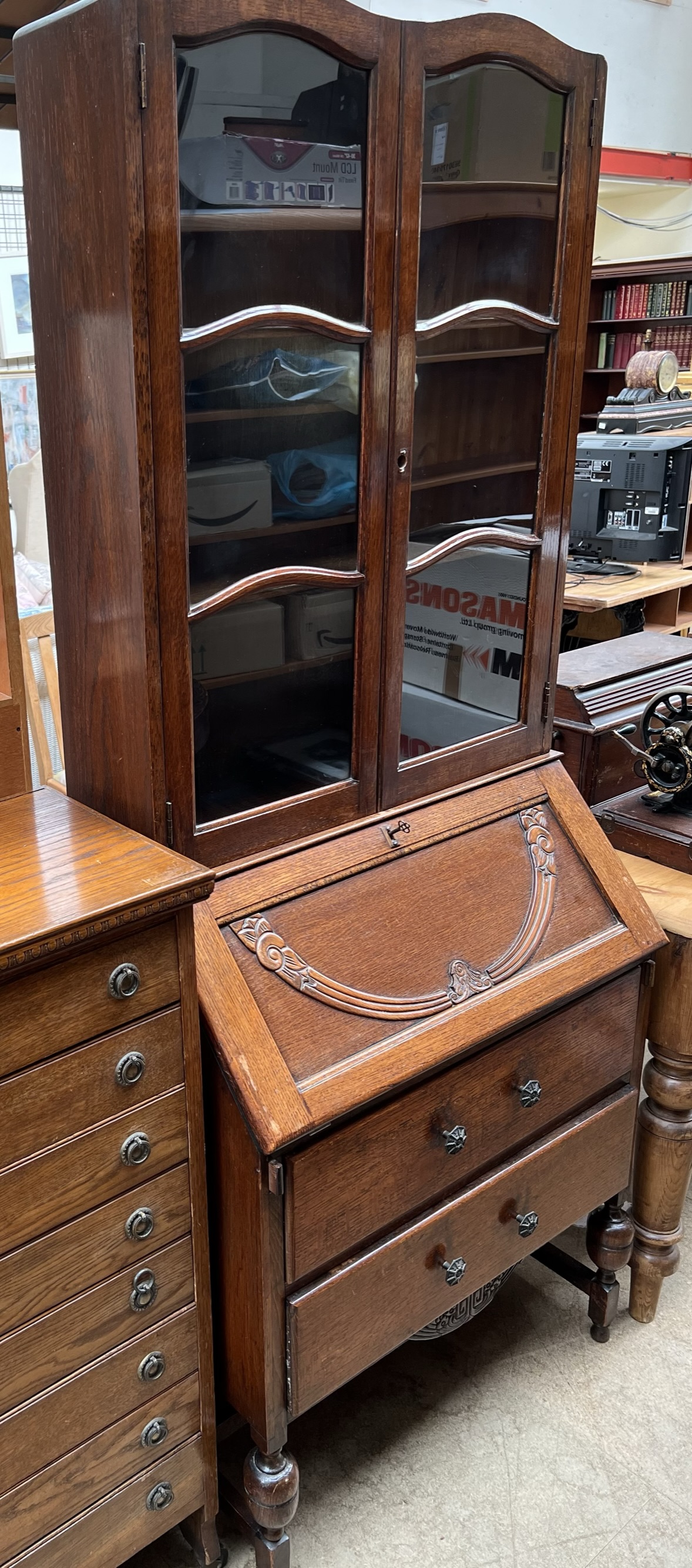 A 20th century oak bureau bookcase, the double camel top with glazed doors,