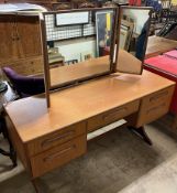 A mid 20th century G-Plan teak dressing table with triple mirror