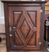 An 18th century hanging corner cupboard, the moulded cornice above a panelled door, 57.