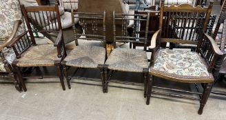 A pair of spindle back dining chairs with rush seats on turned legs together with two spindle back