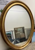 An oval gilt wall mirror