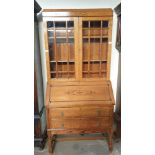 A 20th century oak bureau bookcase with a domed top and glazed doors,