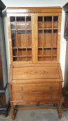 A 20th century oak bureau bookcase with a domed top and glazed doors,