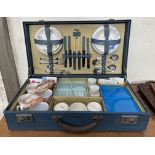 A mid 20th century Sirram picnic suitcase fitted with tea cups and saucers, side plates, cutlery,