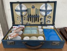 A mid 20th century Sirram picnic suitcase fitted with tea cups and saucers, side plates, cutlery,