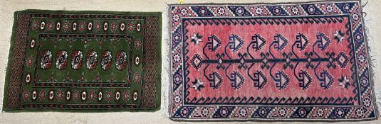A red ground rug with central tree pattern and multiple guard stripes,