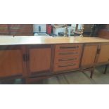 A mid 20th century G-Plan teak sideboard with a rectangular top above a bank of four drawers