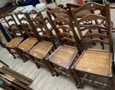 A set of five 18th century style ladder back dining chairs with solid seats on turned legs