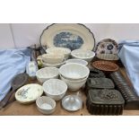 A collection of pottery and tin jelly moulds together with a blue and white meat plate,