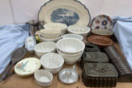 A collection of pottery and tin jelly moulds together with a blue and white meat plate,