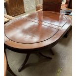 A Chinese hardwood extending dining table of oval form on twin pedestals with splayed legs together