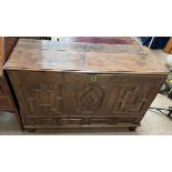 An 18th century carved oak coffer, the rectangular planked top above a three panel front,