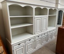 A modern wall unit / bookcase in three sections with cupboards, drawers and shelves,