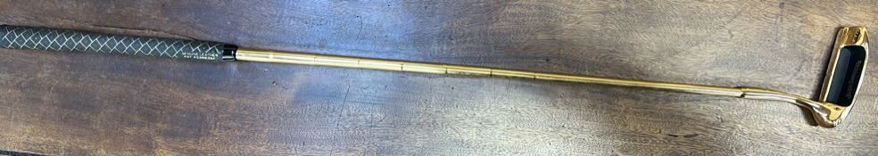 A gilt decorated Jack Daniel's golf putter with a leather grip