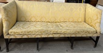 A 19th century mahogany settee with square arms and back on square tapering fluted legs and casters,